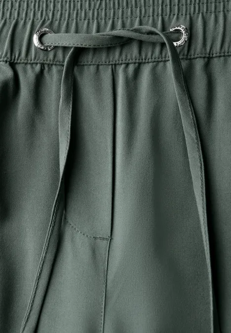 Nahaufnahme einer grünen Hose mit Kordelzug.